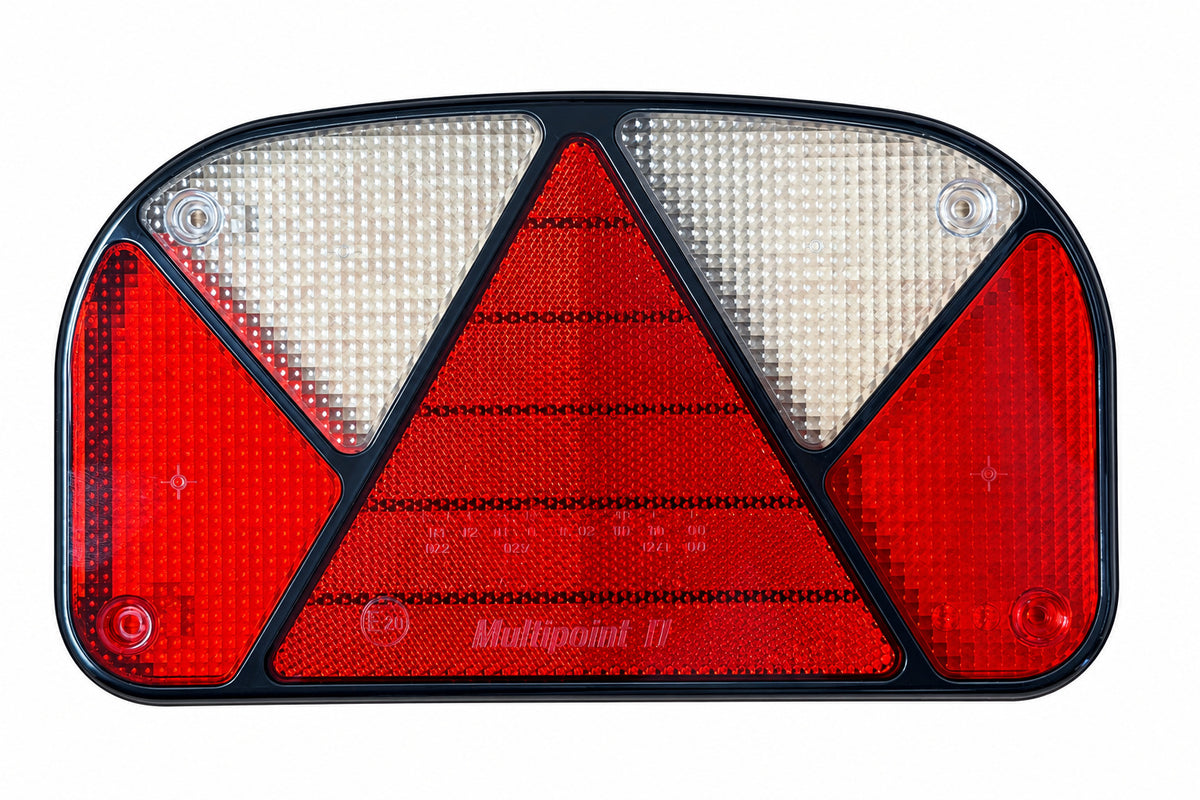 A Multipoint trailer or vehicle rear light assembly with red and clear lenses, mounted on a light wood surface.