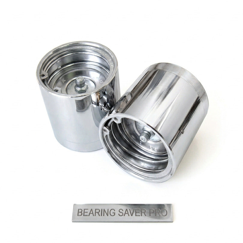 A pair of trailer hub bearing savers with covers, featuring a metallic silver body with a gold-tone interior.